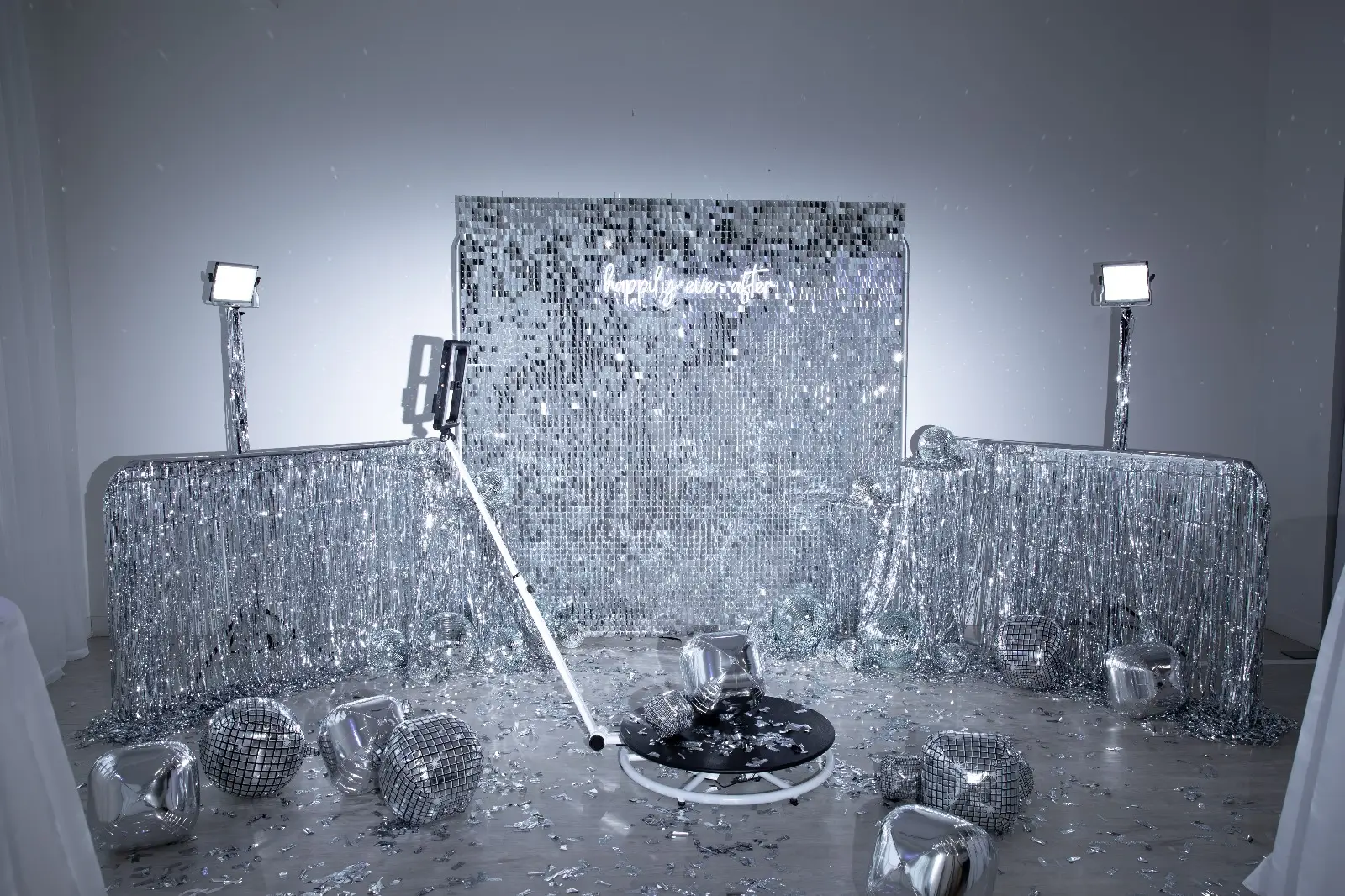 A festive setup featuring silver decorations, disco balls, and lights, creating a vibrant party atmosphere.